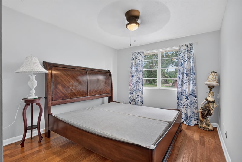 Bedroom with wood bed frame and curtains at 5745 110th St, Jacksonville, FL 32244
