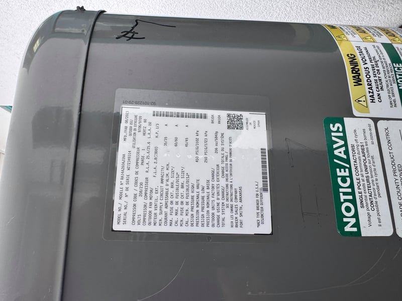 Condenser nameplate with bilingual hazard sticker at 11700 New Kings Rd, Jacksonville, FL 32219