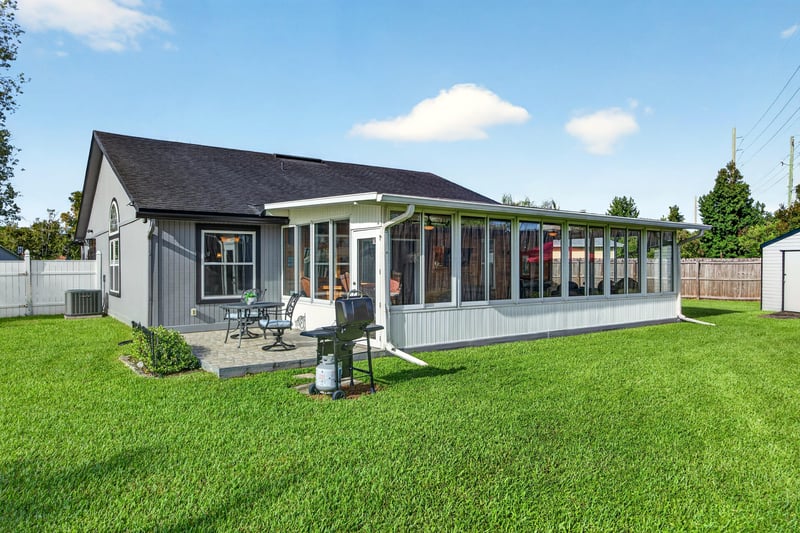 Backyard with sunroom addition and lawn at 6931 Cane Grass Ln E, Jacksonville, FL 32244