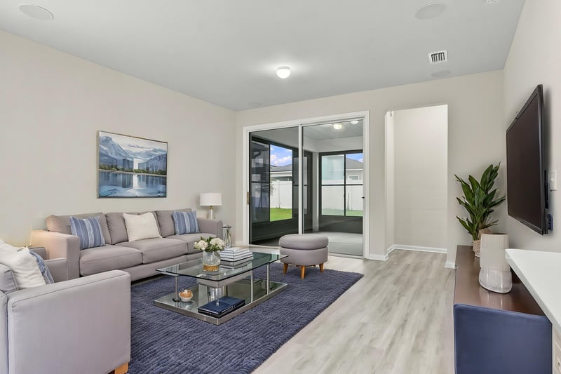 Furnished living room with gray sofa and TV at 7088 Mahogany Run Dr, Jacksonville, FL 32244
