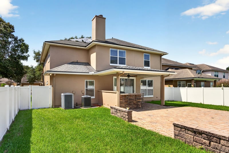 Rear exterior view with paver patio and fenced backyard at 3660 Middlebrook Dr, Orange Park, FL 32065