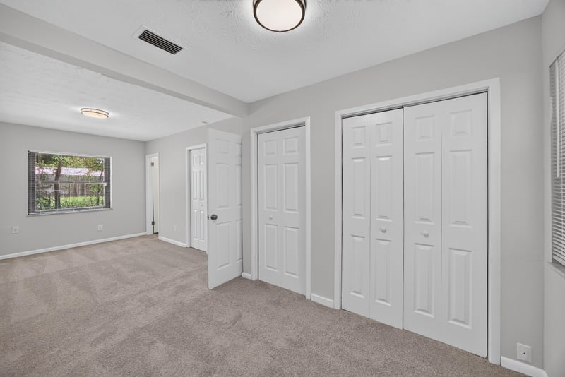 Bedroom with window, carpet and two closet doors at 7453 Jade Dr N, Jacksonville, FL 32210