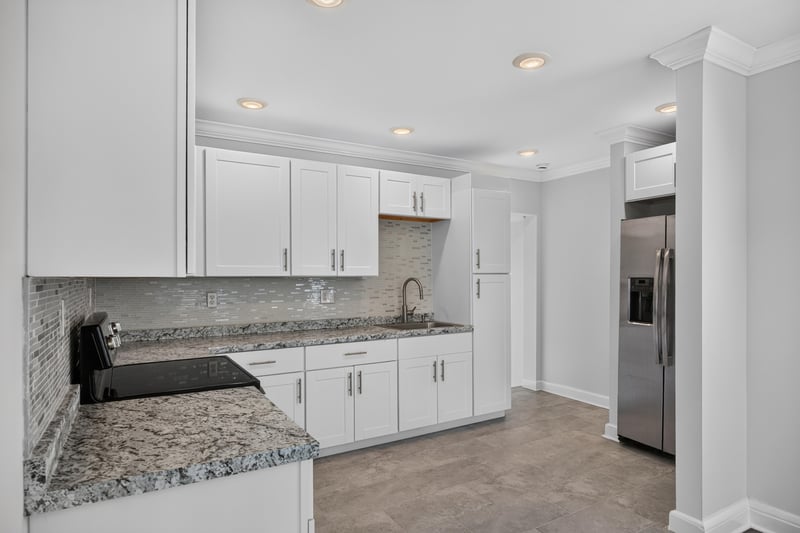 Kitchen with white cabinets, granite counters and stainless fridge at 316 W 41st St, Jacksonville, FL 32206