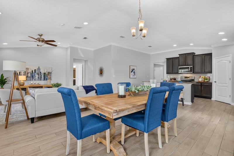 Dining area with blue chairs and pendant lighting at 10066 Andean Fox Dr, Jacksonville, FL 32222