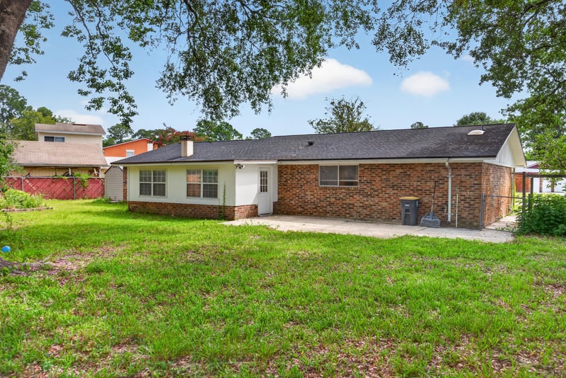 Backyard lawn and brick exterior at 9954 Larkdale Ct, Jacksonville, FL 32257