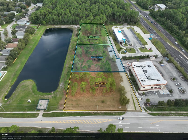 Aerial view of the pond with the wooded parcel and building beyond at 4900 US-1, St. Augustine, FL 32086