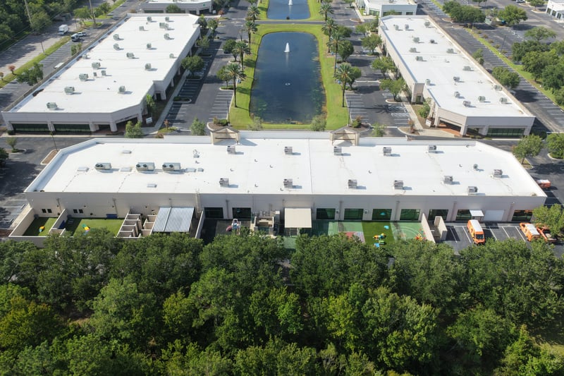 Aerial view of a building roof bordered by trees at 10550 Deerwood Park Blvd, Jacksonville, FL 32256