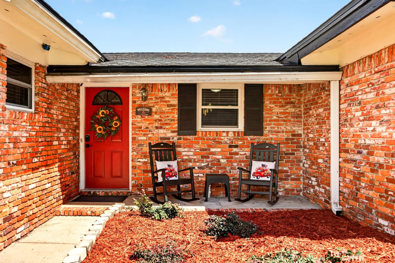 Covered front entry with red door and rocking chairs at 6059 Karen St, Jacksonville, FL 32244