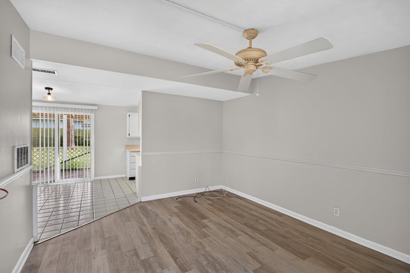Living room with wood floor, ceiling fan, and sliding doors at 87 Saratoga Cir S, Atlantic Beach, FL