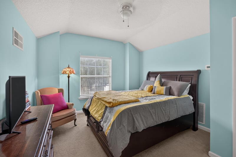 Bedroom with dark wood bed and accent chair at 3112 Silverado Cir, Green Cove Springs, FL 32043