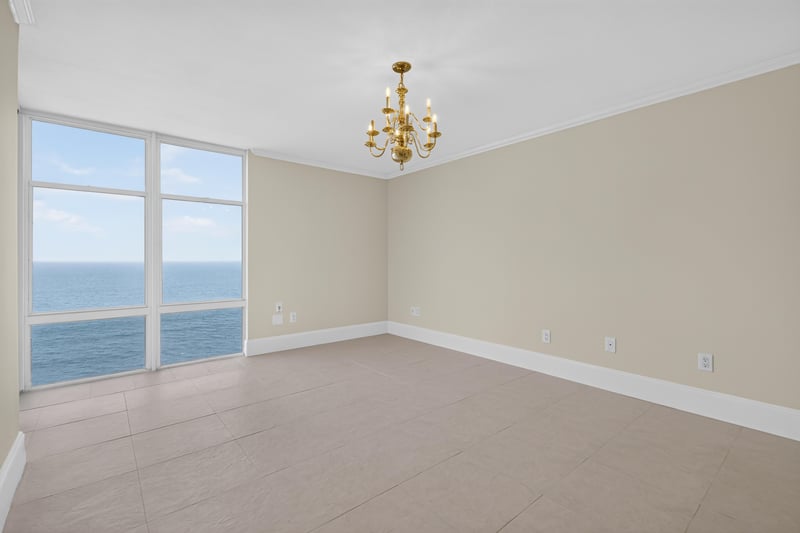 Empty room with chandelier and ocean view windows at 1301 1st St S
