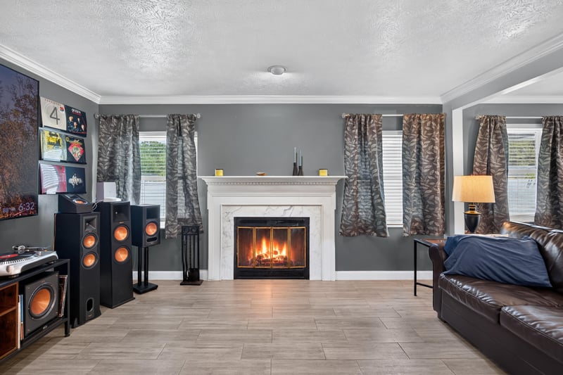 Living room fireplace with lit mantle and wood flooring at 6059 Karen St, Jacksonville, FL 32244