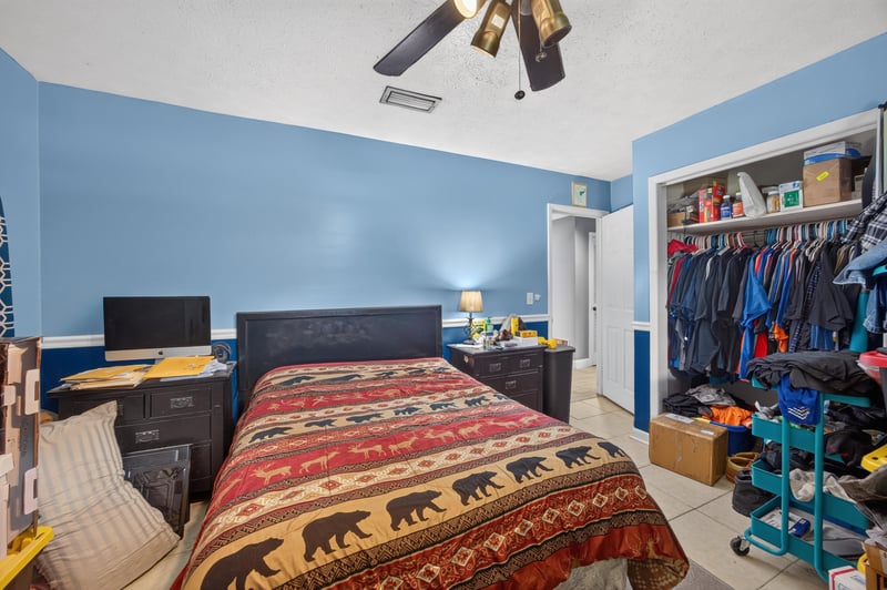 Bedroom with blue walls and closet storage at 6059 Karen St, Jacksonville, FL 32244
