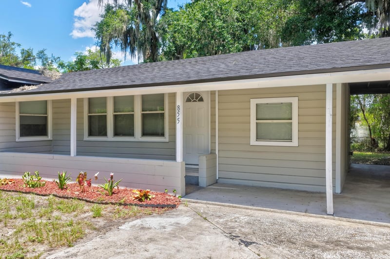 Front exterior close-up with flower bed and carport at 855 Cornwallis Dr, Jacksonville, FL
