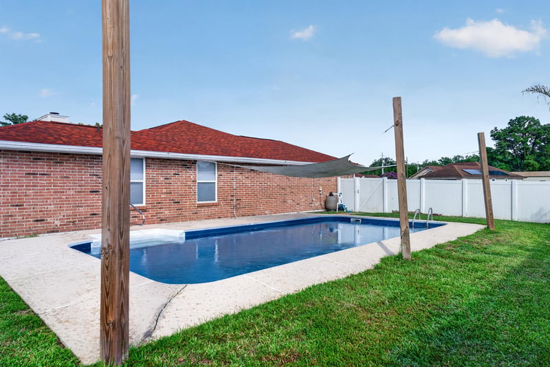 Backyard pool with view of the brick home at 2164 Orangewood St, Middleburg, FL 32068