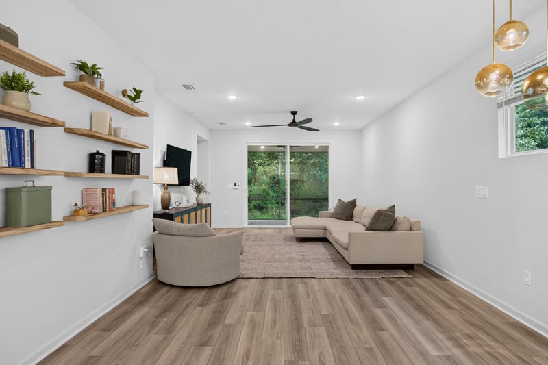 Living room with sectional and sliding glass doors at 93 Lochloosa Ct, St. Johns, FL 32259