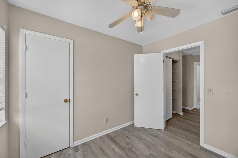 Hallway with white doors and wood-look flooring at 2658 Trollie Ln apt 1, Jacksonville, FL 32211