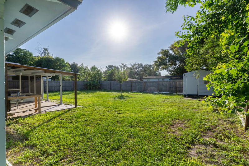 Fenced backyard with covered patio and morning sun at 442 Ameca Ave, Orange Park, FL 32073