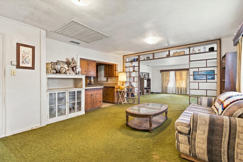 Living room with green carpet and built-in shelving at 1807 Idlewild Ave, Green Cove Springs, FL