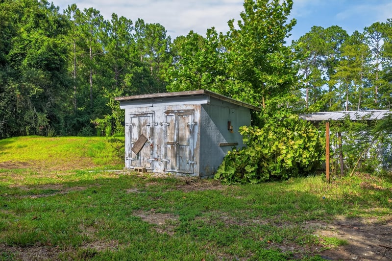 Storage shed in the wooded backyard at 55520 Jewel-Thomas Rd, Callahan, FL 32011
