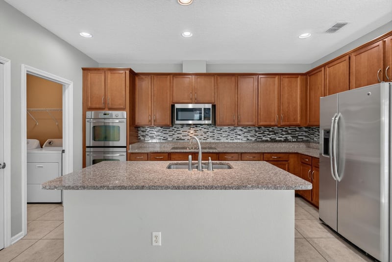 Kitchen with tile backsplash and stainless refrigerator at 13685 Goodson Pl, Jacksonville, FL 32226
