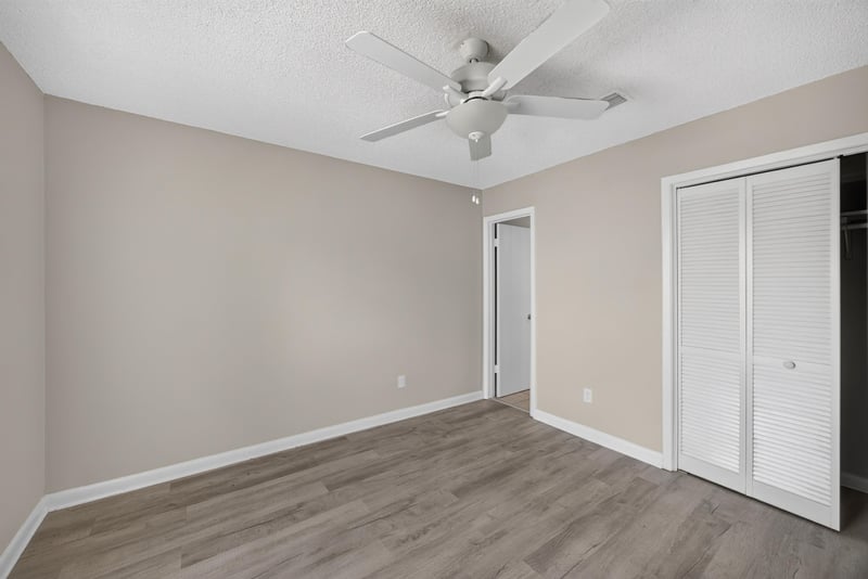 Bedroom with sliding closet doors and ceiling fan at 2717 Trollie Ln, Jacksonville, FL