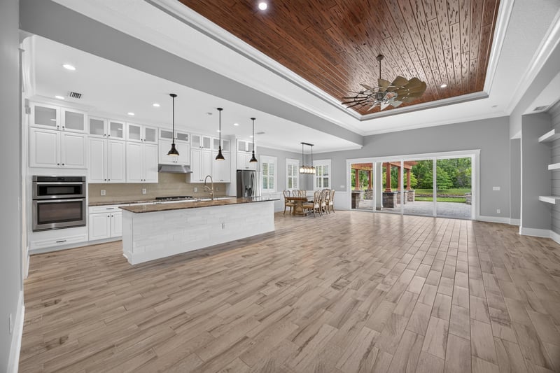 Kitchen and great room with wood tray ceiling and pendant lights at 186 Freshwater Dr