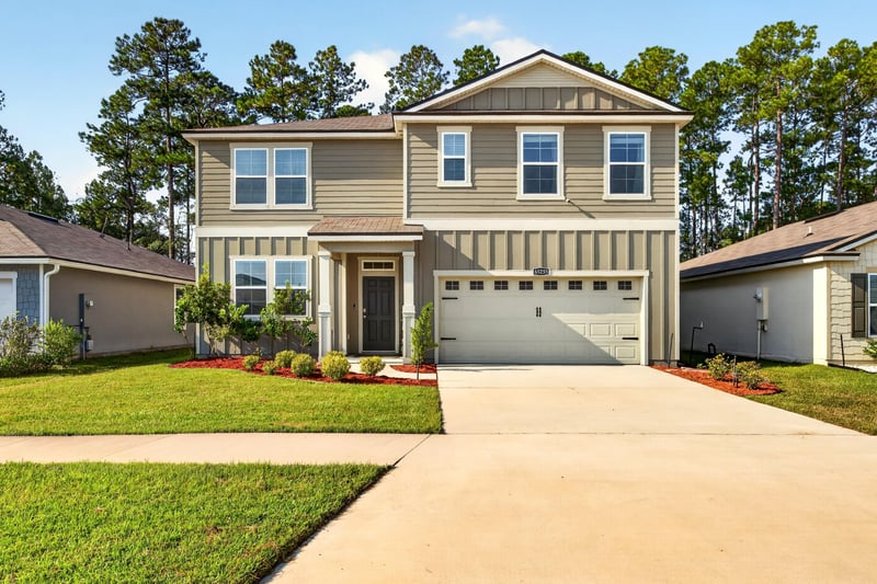Front exterior view of two-story home and driveway at 65255 Frst Glen Ln, Yulee, FL 32097