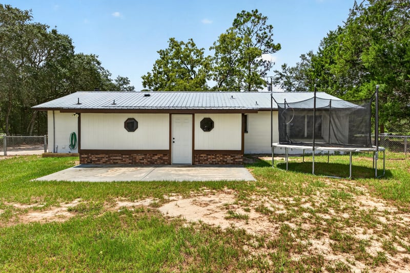 Rear exterior with screened porch and round window at 6757 Deer Springs Rd, Keystone Heights, FL 32656