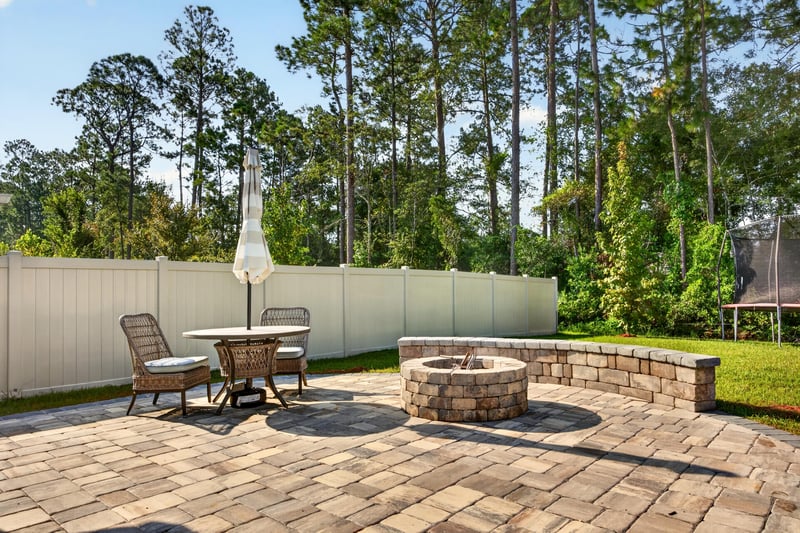 Paver patio with fire pit and fenced yard at 65255 Frst Glen Ln, Yulee, FL 32097