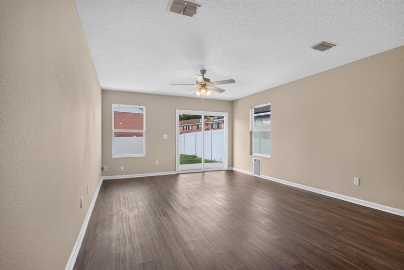 Living room, empty, wood-look flooring and windows at 7253 Townsend Village Ct, Jacksonville, FL