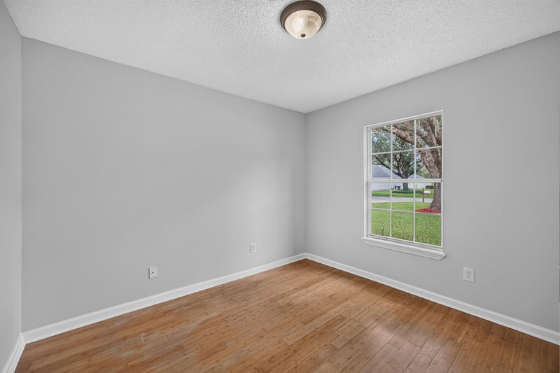 Empty bedroom with wood floors and window at 456 Bay Point Way N, Jacksonville, FL 32259