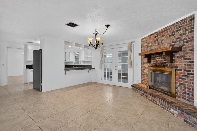 Living room brick fireplace with french doors at 9954 Larkdale Ct, Jacksonville, FL 32257