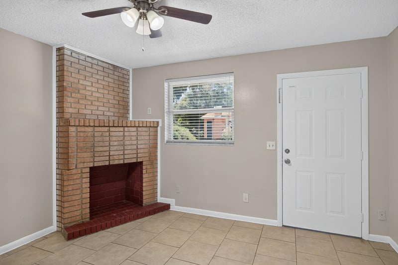 Living room with brick fireplace and ceiling fan at 8067 Parental Cir, Jacksonville, FL 32216