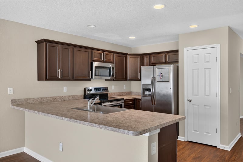 Kitchen wide view with dark cabinets and hallway at 7253 Townsend Village Ct, Jacksonville, FL