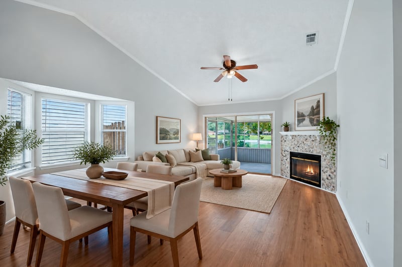 Virtually staged living and dining area with fireplace and wood floors at 8047 Mactavish Way E, Jacksonville, FL 32244