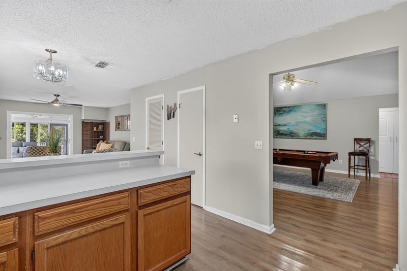Kitchen pass-through with pool table beyond at 8680 Bandera Cir S, Jacksonville, FL 32244