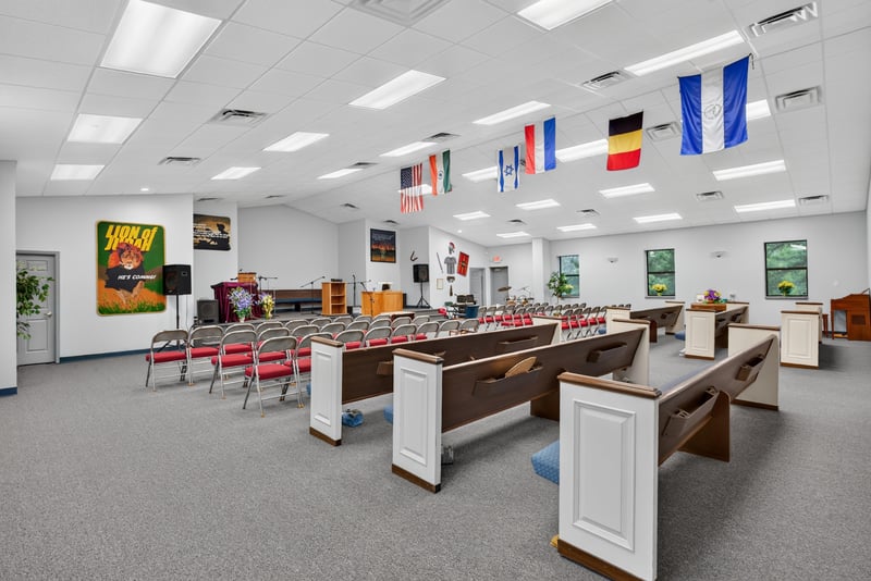 Assembly hall with pews, red chairs and hanging flags at 1038 County Rd 315, Melrose