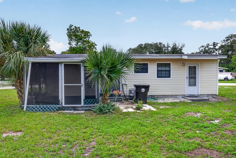Rear exterior with screened porch and open yard at 255 Woodside Dr, Orange Park, FL 32073