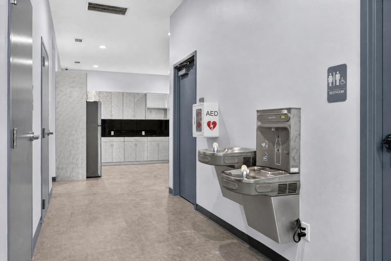 Hallway with water fountain, AED unit, and restroom sign at 7240 Golden Wings Rd building 100, Jacksonville, FL 32244