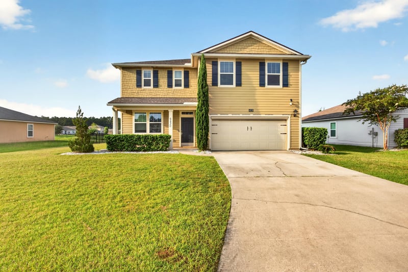 Front exterior close-up with driveway and garage doors at 6830 Hanford St, Jacksonville, FL 32219