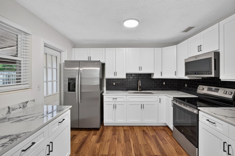 Kitchen with white cabinets and stainless appliances at 4039 Habana Ave, Jacksonville, FL