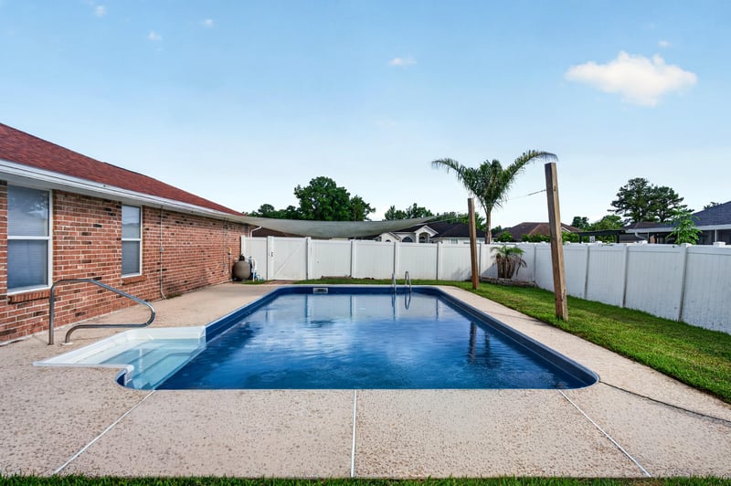 Backyard pool view with palm tree and privacy fence at 2164 Orangewood St, Middleburg, FL 32068