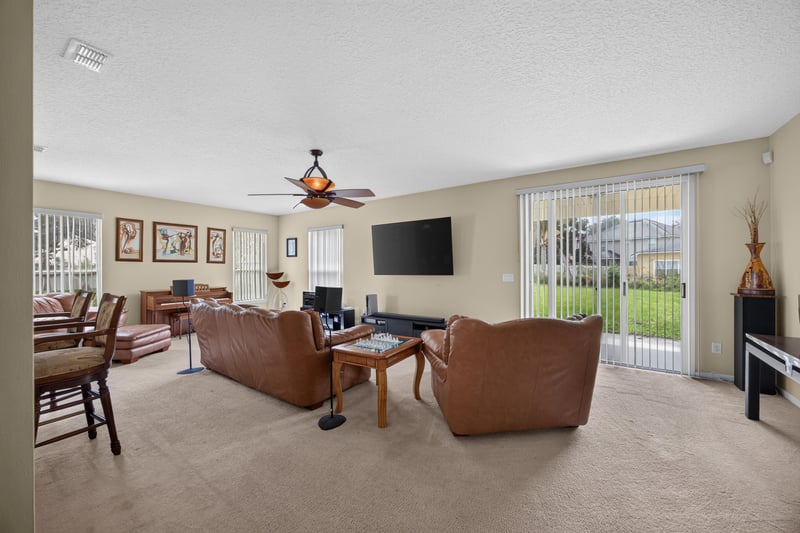Family room with ceiling fan and sliding glass door at 2875 Pebblewood Ln, Orange Park, FL 32065