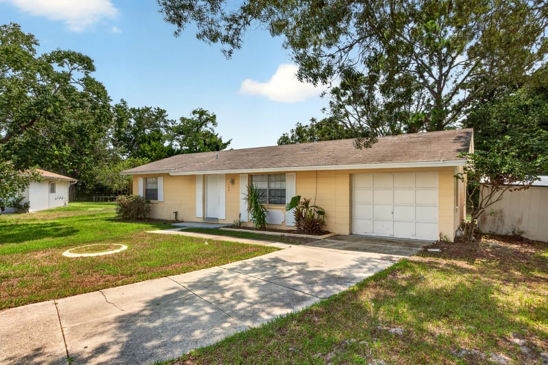 Side angle of front exterior with shade trees and walkway at 328 Palos Ct, St. Augustine, FL