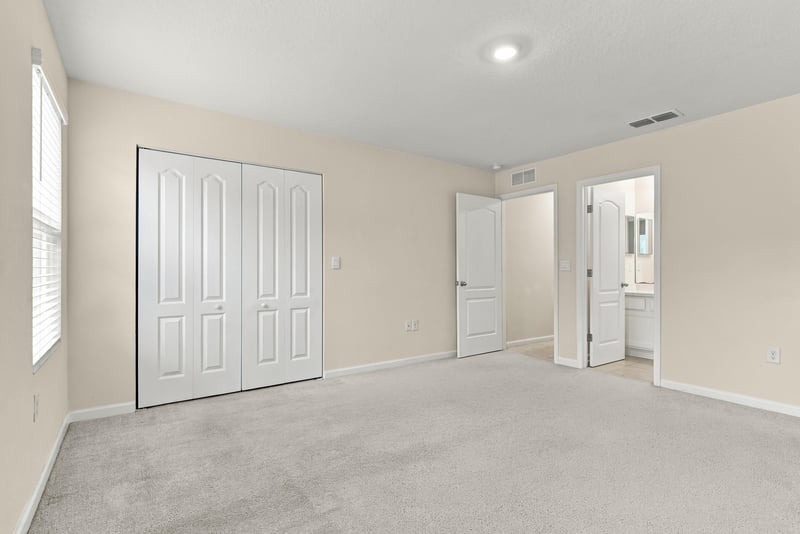 Empty bedroom with closet doors and carpet at 9555 Star Dr, Jacksonville, FL 32256