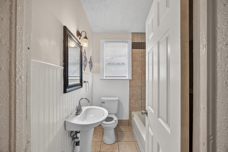 Bathroom with pedestal sink and toilet at 1473 State St W, Jacksonville, FL 32209