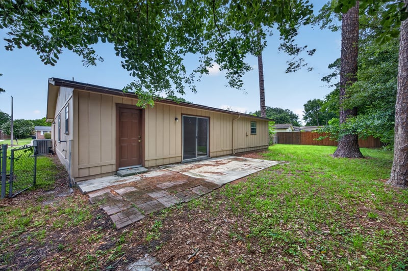 Backyard view of side exterior with patio and sliding door at 1083 Stokes St, Jacksonville, FL