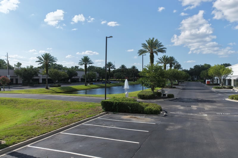 Pond with fountain beside palm-lined parking lot at 10550 Deerwood Park Blvd, Jacksonville, FL 32256