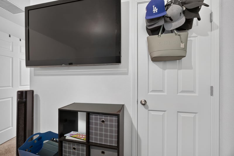 Bedroom or office with mounted TV and storage bins at 518 Matecumbe Ct, Macclenny, FL